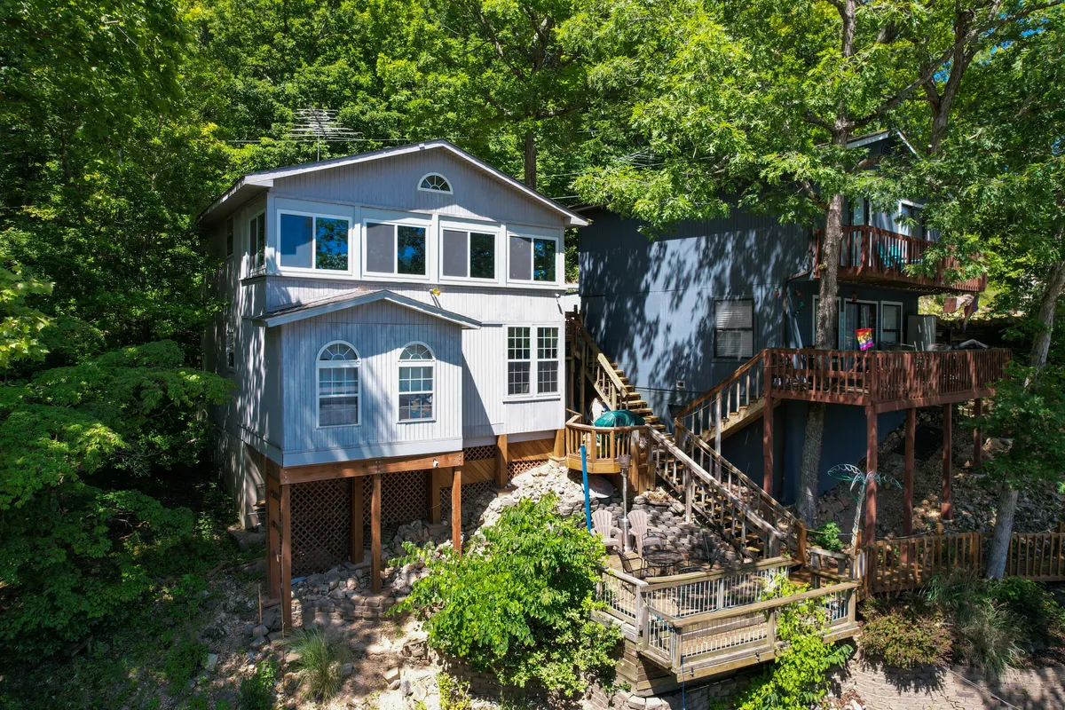The wooden deck of the house surrounded by trees and nature, with large windows that blur the line between indoor comfort and the great outdoors. The deck provides an ideal spot for unwinding after a day of adventure, watching sunsets, or enjoying morning coffee amid tranquil surroundings.