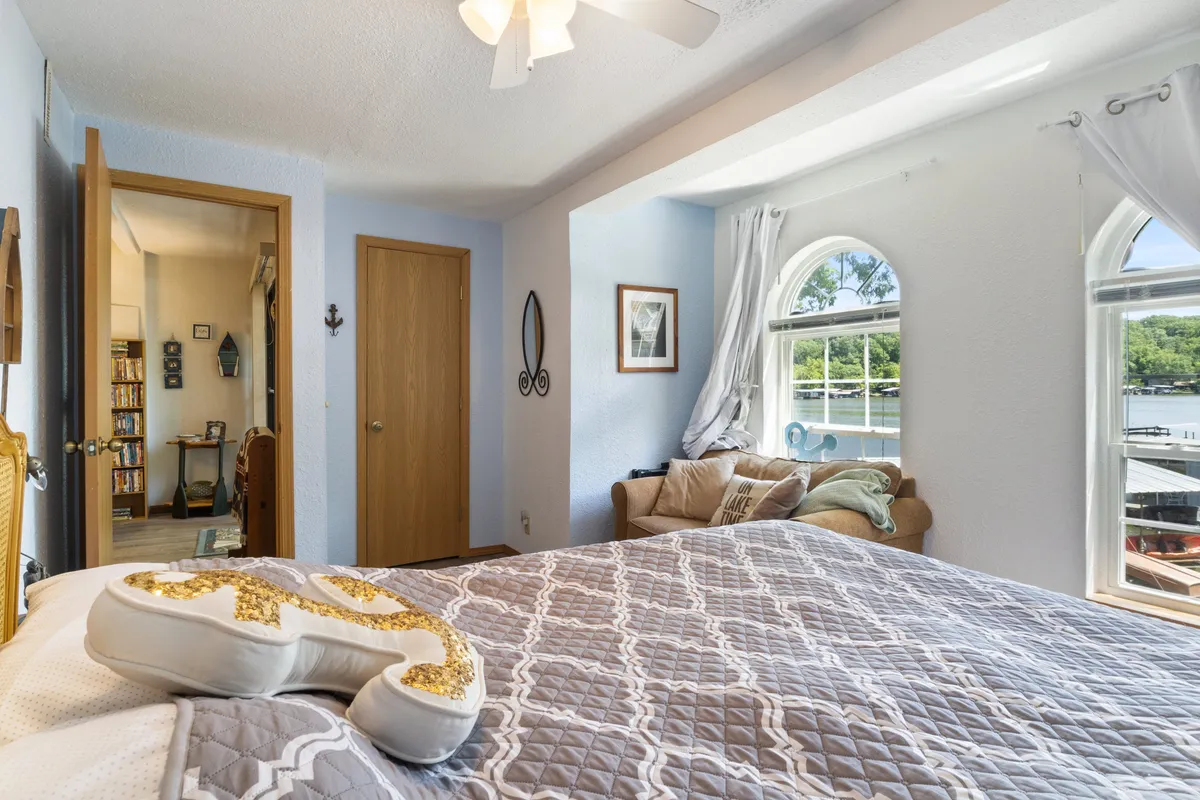 A tranquil bedroom with a cozy bed dressed in soft linens, a large window showcasing beautiful views, and a comfortable armchair positioned for reading or relaxation. The serene ambiance makes it perfect for a restful night's sleep or a quiet morning.