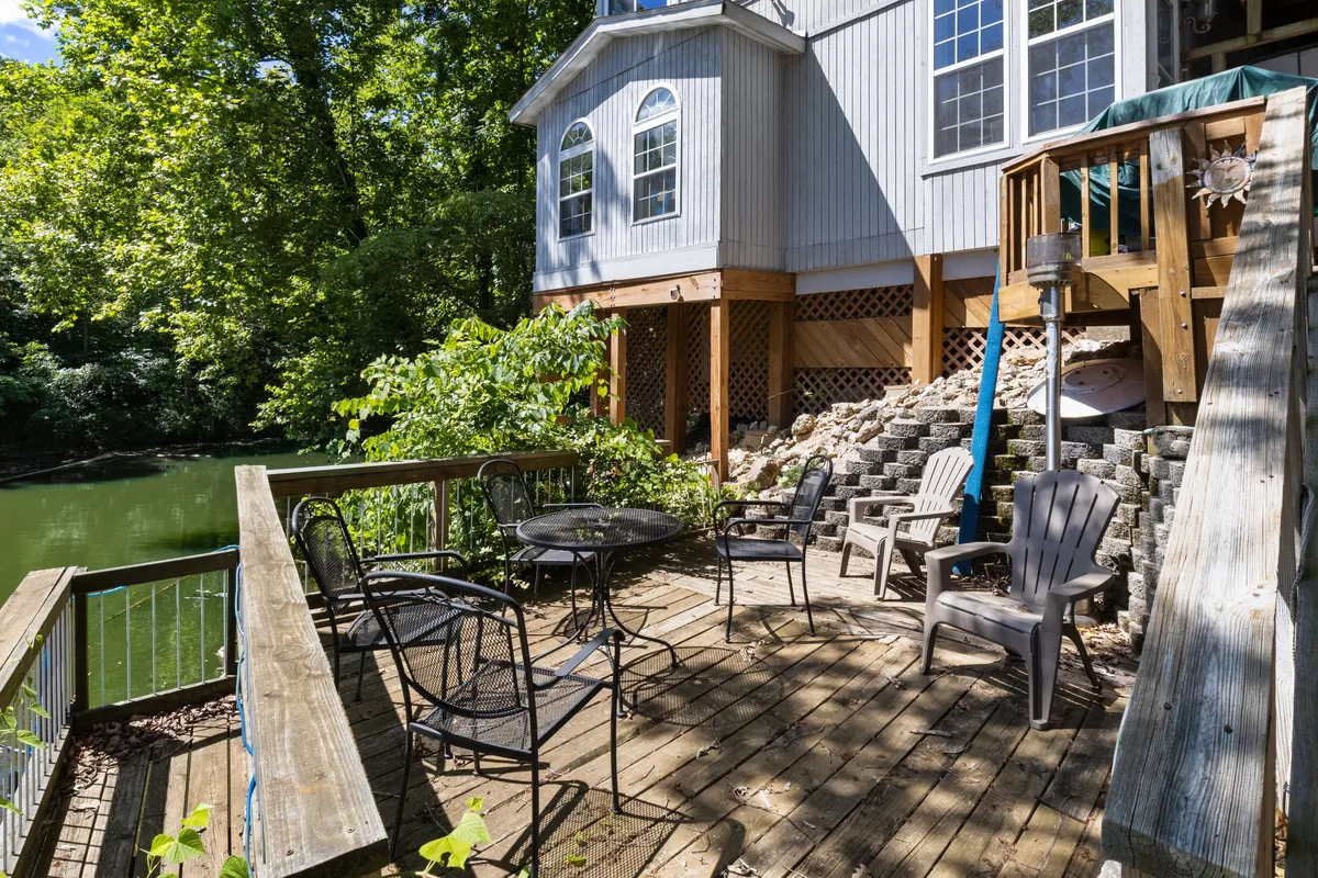 A serene deck area with outdoor seating, positioned to take in views of the water and lush surroundings. The setup encourages relaxation, meals, and socializing, whether by day or under the stars at night.